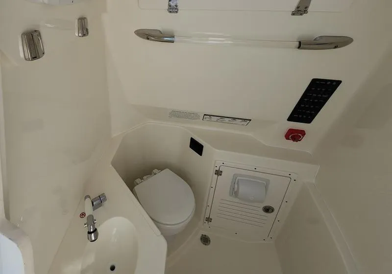 Slide: The Image of 2025 Cobia 265 Center Console interior with toilet and sink. - 22