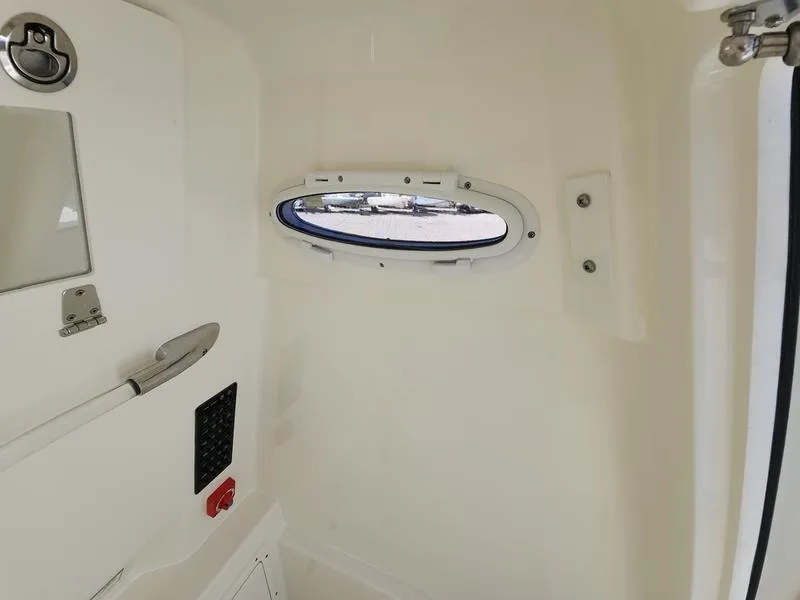 Slide: The Image of Interior view of 2025 Cobia 265 Center Console boat with porthole and control panel. - 23