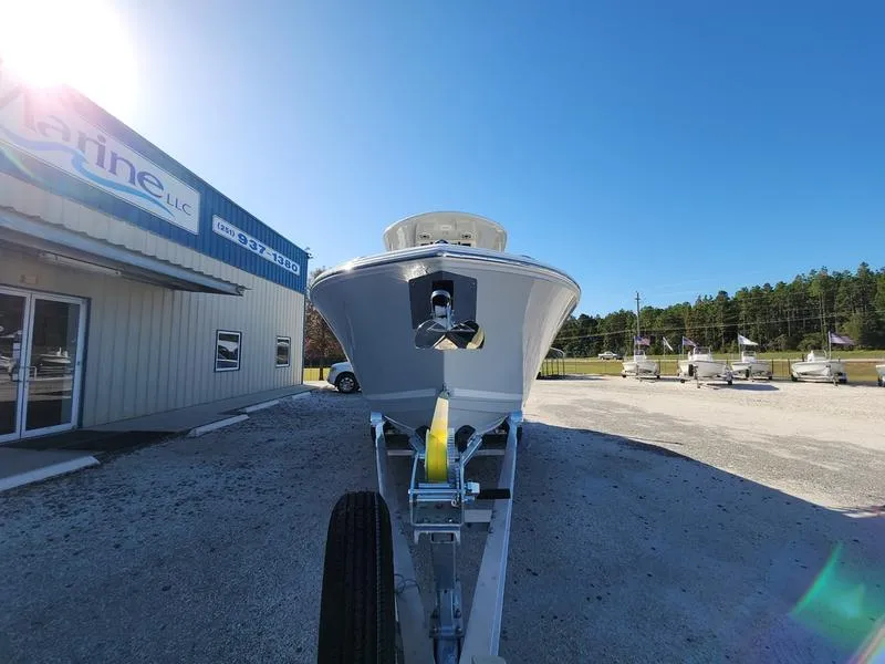 Slide: The Image of 2025 Cobia 265 Center Console boat on trailer outside dealership under clear blue sky. - 3