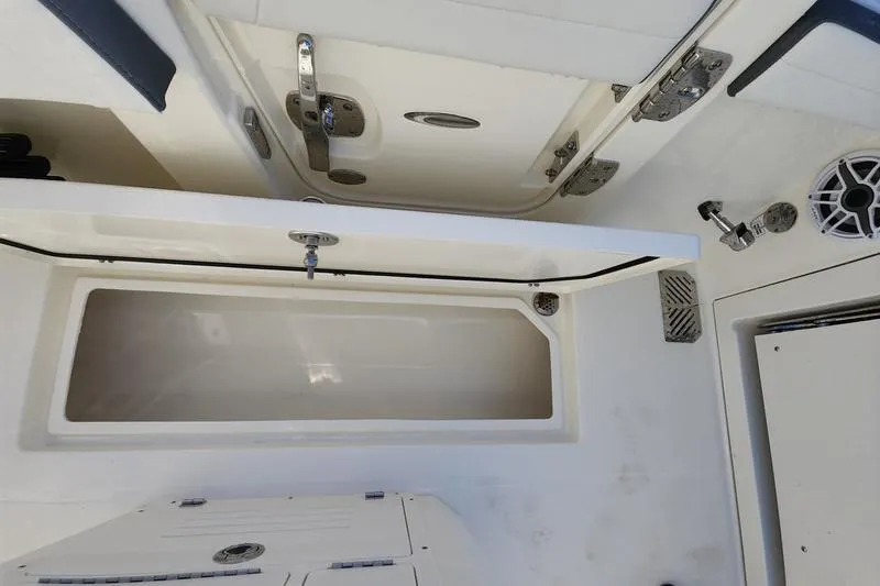 Slide: The Image of 2025 Cobia 265 Center Console boat interior with open storage compartment and stainless steel fixtures. - 33