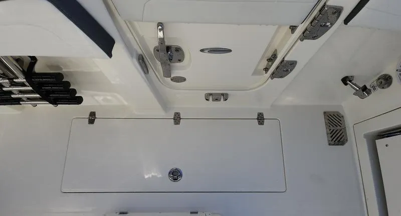 Slide: The Image of 2025 Cobia 265 Center Console boat deck with storage compartments and rod holders. - 34