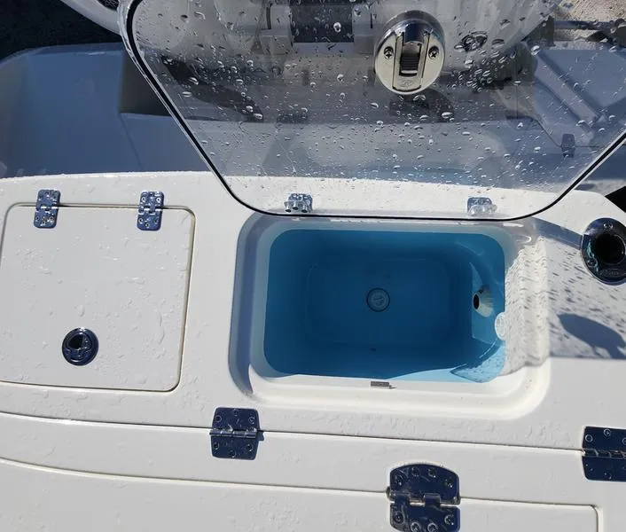 Slide: The Image of 2025 Cobia 265 Center Console boat with open storage compartment and water droplets. - 37