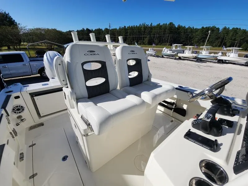 Slide: The Image of 2025 Cobia 265 Center Console boat with dual white captain seats and control panel. - 8
