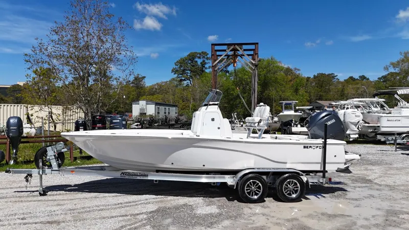 The Image of 2025 Sea Fox 231 Bay Fox boat on trailer, parked outdoors under clear blue sky. - 0