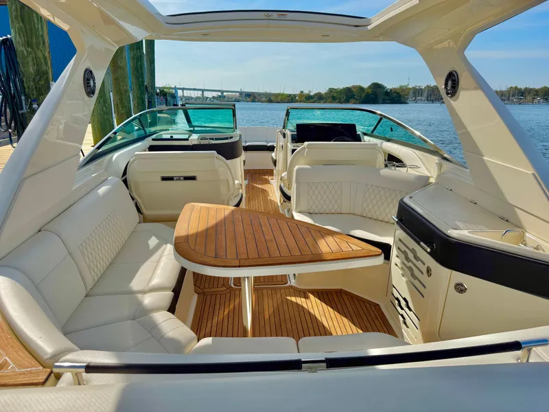Slide: The Image of 2019 Sea Ray SLX 310 boat interior with luxurious seating and wooden table. - 14