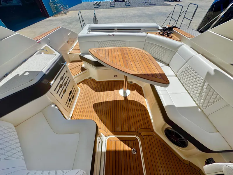 Slide: The Image of Luxurious 2019 Sea Ray SLX 310 boat interior with elegant seating and wooden table. - 15