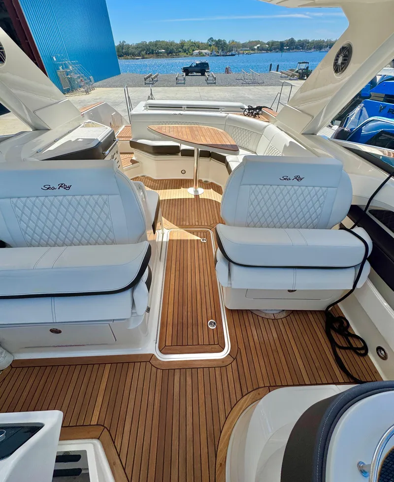 Slide: The Image of 2019 Sea Ray SLX 310 boat interior with luxurious seating and wooden flooring. - 19