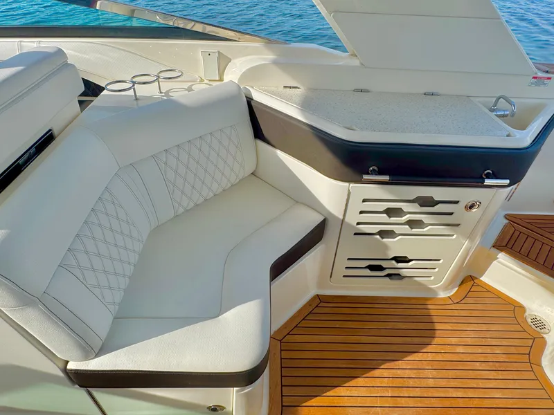 Slide: The Image of Luxurious 2019 Sea Ray SLX 310 boat interior with white seating and wooden flooring. - 22