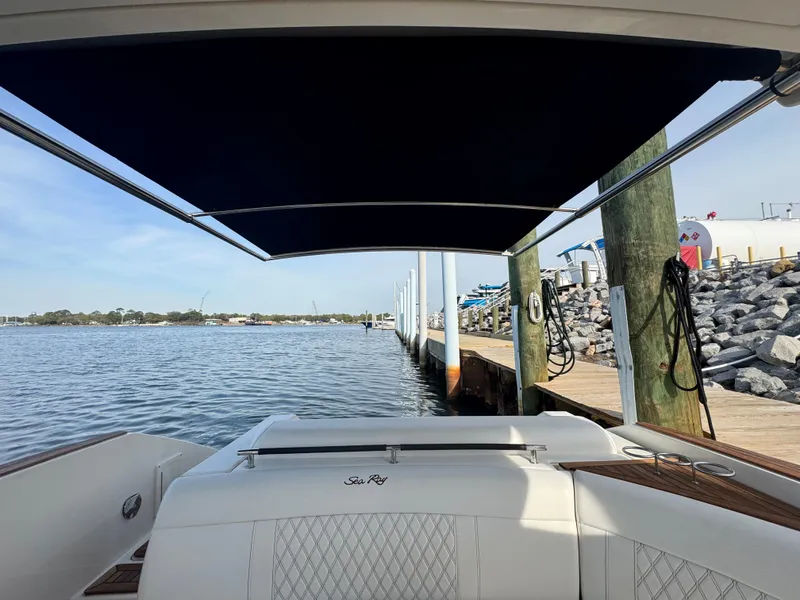 Slide: The Image of 2019 Sea Ray SLX 310 boat docked by a calm waterfront. - 27