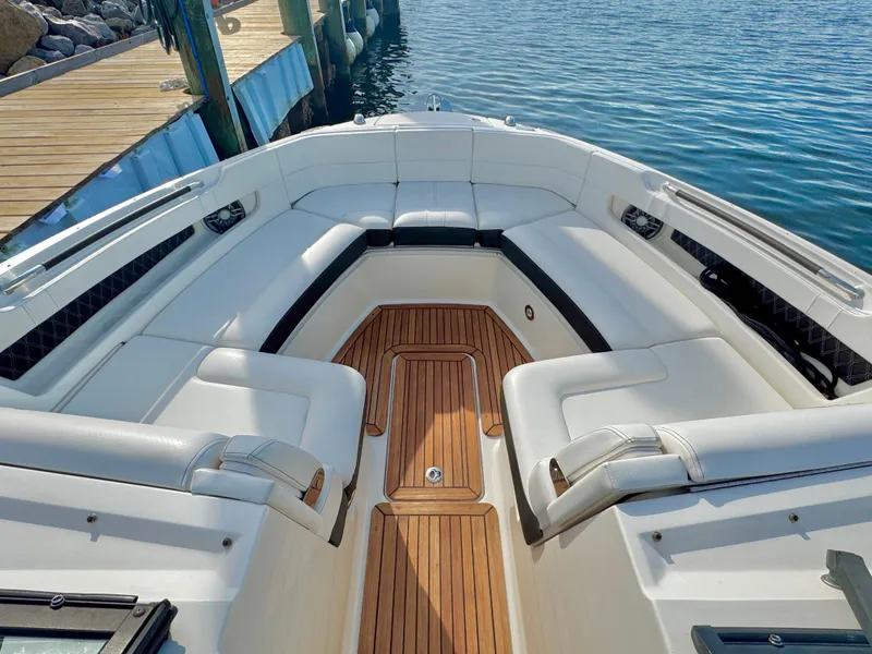 Slide: The Image of 2019 Sea Ray SLX 310 boat with spacious seating and wooden deck, docked by the water. - 30