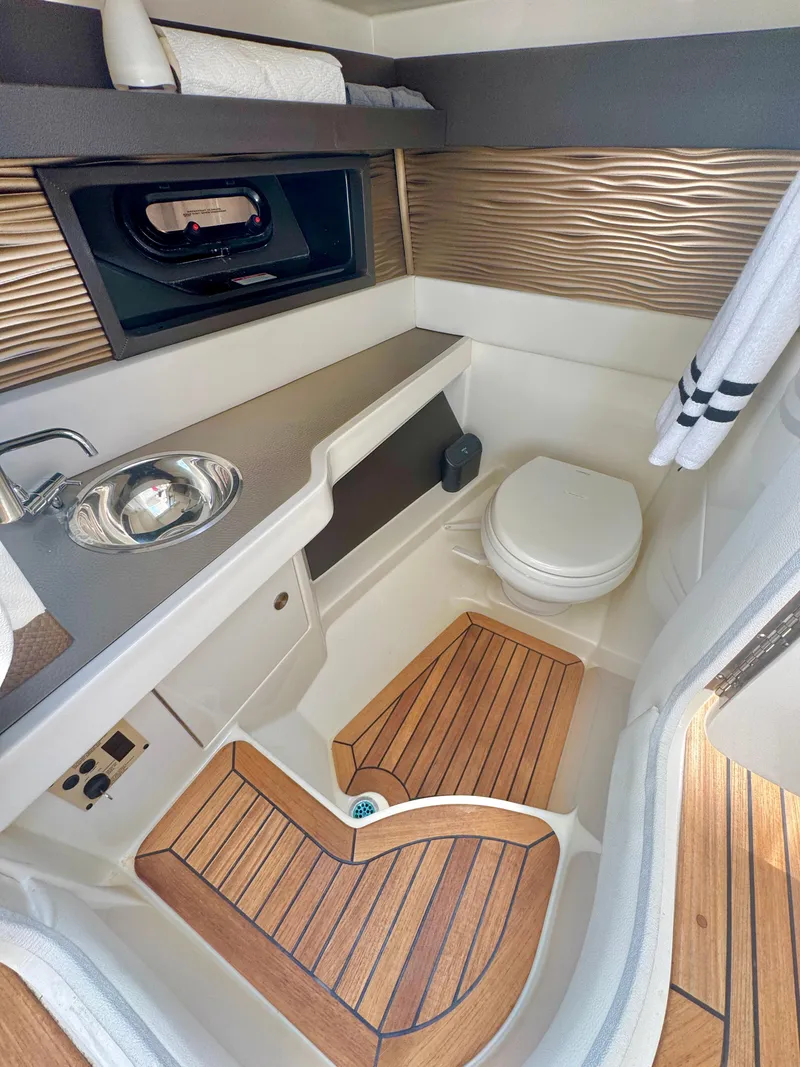 Slide: The Image of Luxurious 2019 Sea Ray SLX 310 boat bathroom with wood flooring and modern fixtures. - 31
