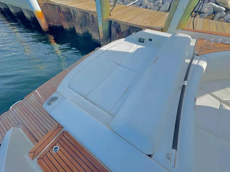 Slide: The Image of 2019 Sea Ray SLX 310 boat with white seating and wooden deck by the water. - 33