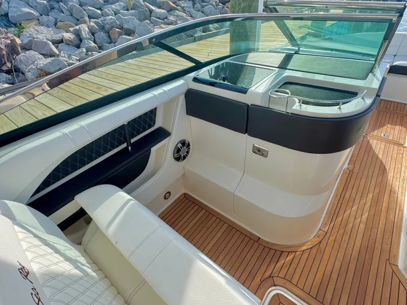 Slide: The Image of 2019 Sea Ray SLX 310 boat interior with teak flooring and cushioned seating. - 36