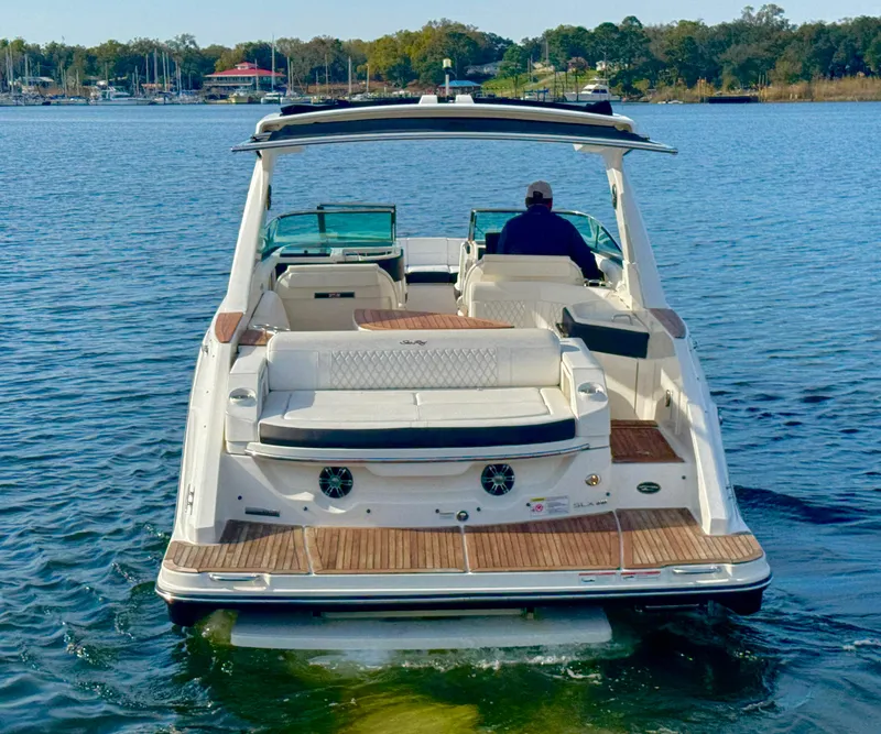 Slide: The Image of 2019 Sea Ray SLX 310 boat on water, rear view, with person at helm. - 6