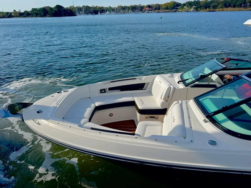 Slide: The Image of 2019 Sea Ray SLX 310 boat on calm water, featuring spacious seating and sleek design. - 7