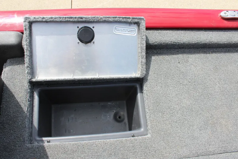 Slide: The Image of 2022 Tracker Pro Team 175 TXW boat storage compartment with open lid, gray interior, and red trim. - 21