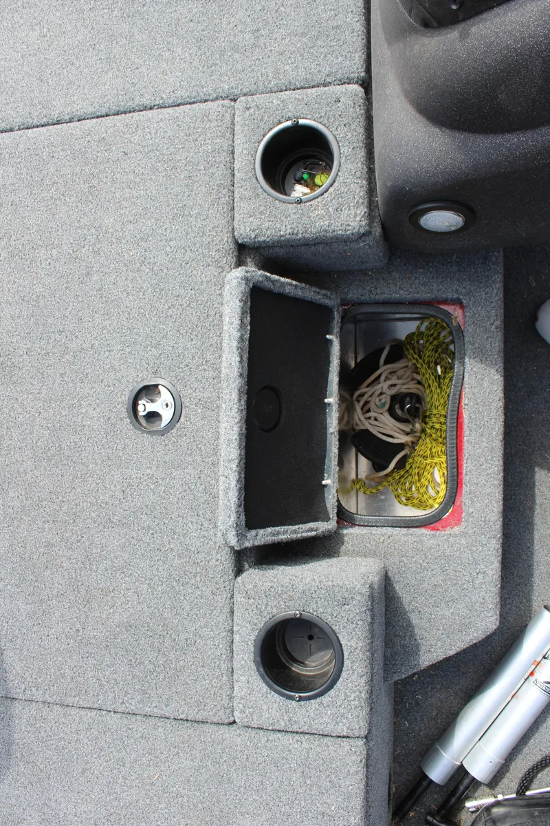 Slide: The Image of 2022 Tracker Pro Team 175 TXW boat storage compartment with cup holders and fishing gear. - 24