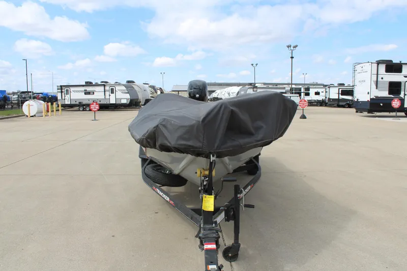 Slide: The Image of 2022 Tracker Pro Team 175 TXW boat covered, parked in a lot with RVs in the background. - 9