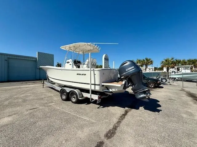 Slide: The Image of 2016 Regulator 25 boat on trailer with Yamaha outboard, parked outdoors under clear blue sky. - 10