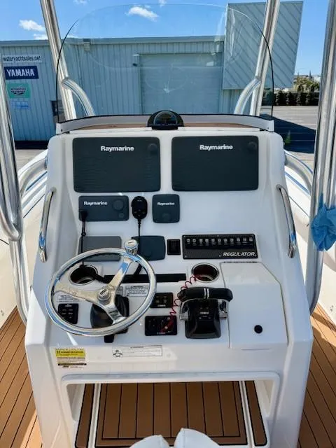 Slide: The Image of 2016 Regulator 25 boat console with Raymarine electronics and steering wheel. - 11