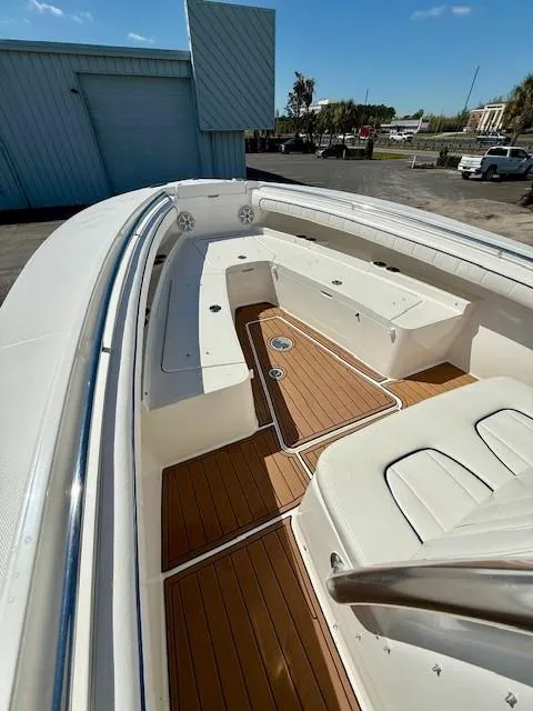 Slide: The Image of 2016 Regulator 25 boat with teak deck and white seating, docked outdoors. - 17