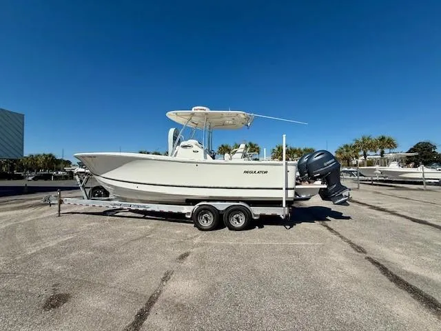 Slide: The Image of 2016 Regulator 25 boat on trailer under clear blue sky. - 3