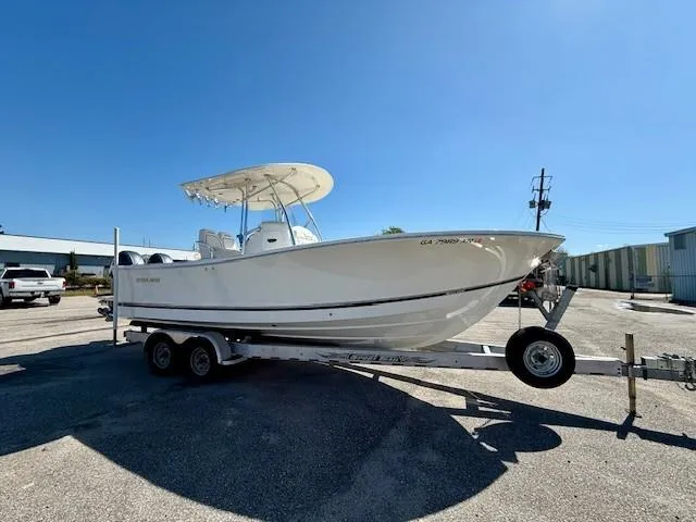 Slide: The Image of 2016 Regulator 25 boat on trailer under clear blue sky. - 8