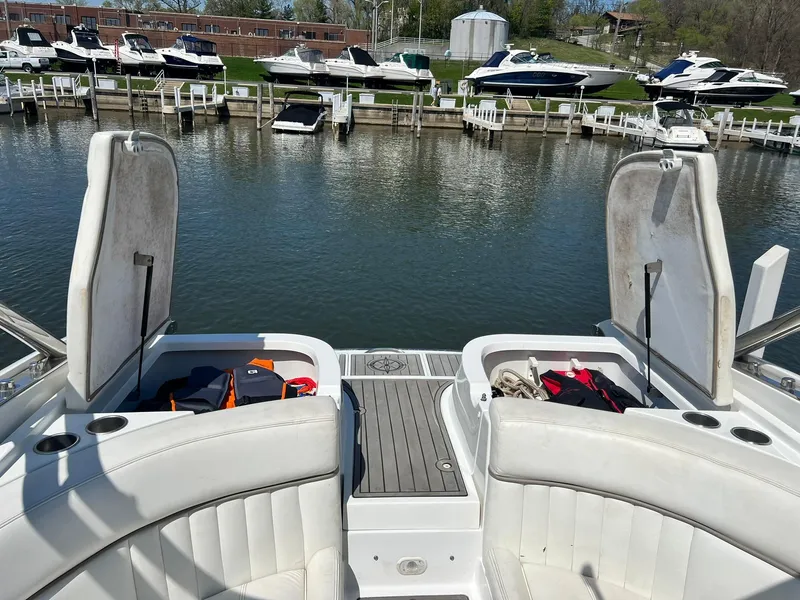 Slide: The Image of 2004 Cobalt 282 boat with open storage compartments, docked at a marina with other boats. - 13