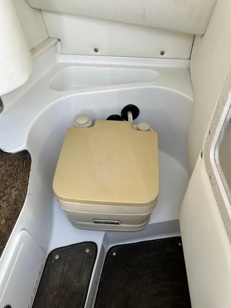 Slide: The Image of 2004 Cobalt 282 boat interior with portable toilet in compact space. - 29