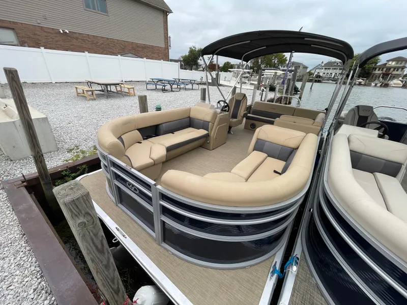 Slide: The Image of 2023 Harris Cruiser 230 pontoon boat docked, featuring spacious seating and modern design. - 1