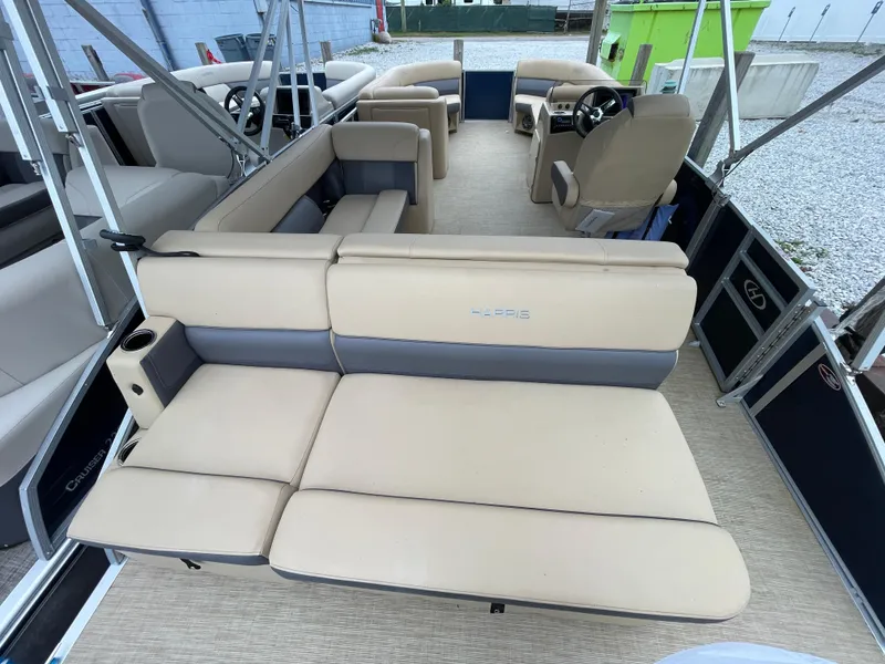 Slide: The Image of 2023 Harris Cruiser 230 pontoon boat with beige seating and spacious interior layout. - 10