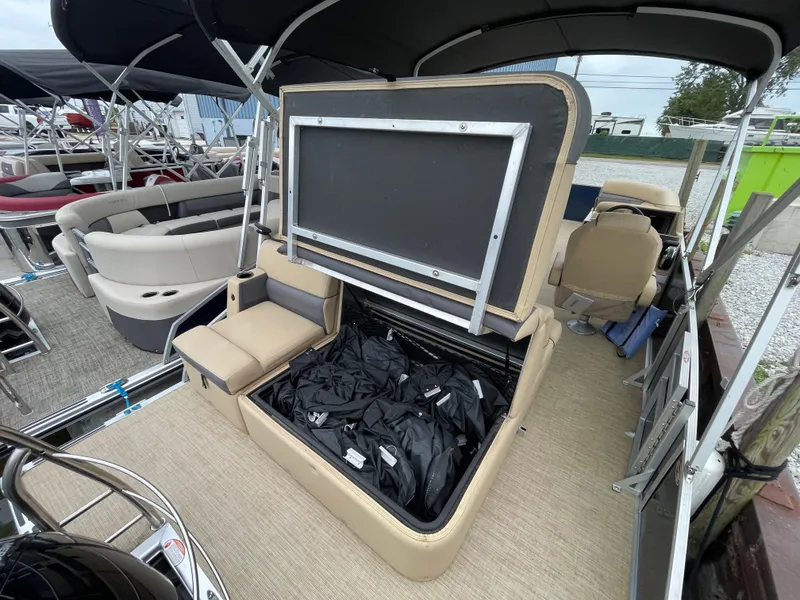 Slide: The Image of 2023 Harris Cruiser 230 boat with open storage compartment and seating area. - 11