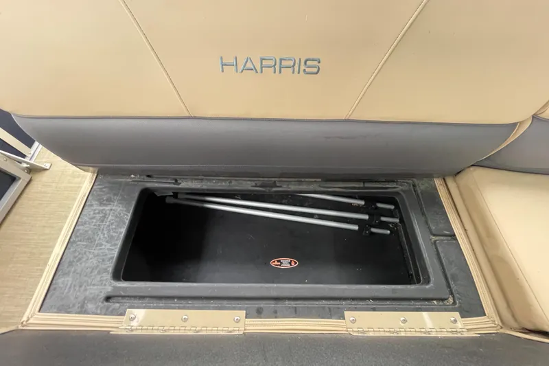 Slide: The Image of 2023 Harris Cruiser 230 storage compartment with beige seating and black interior. - 18