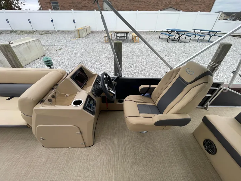 Slide: The Image of 2023 Harris Cruiser 230 boat interior with beige seating and steering console. - 20