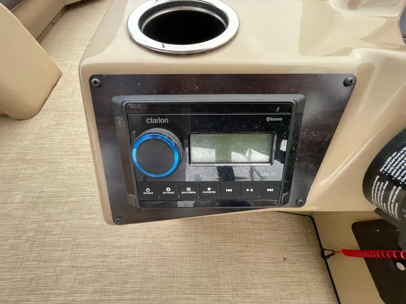 Slide: The Image of 2023 Harris Cruiser 230 boat console with Clarion audio system and cup holder. - 22