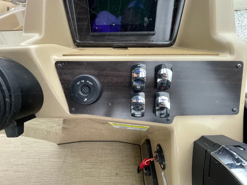 Slide: The Image of Control panel of 2023 Harris Cruiser 230 boat with switches and ignition. - 23
