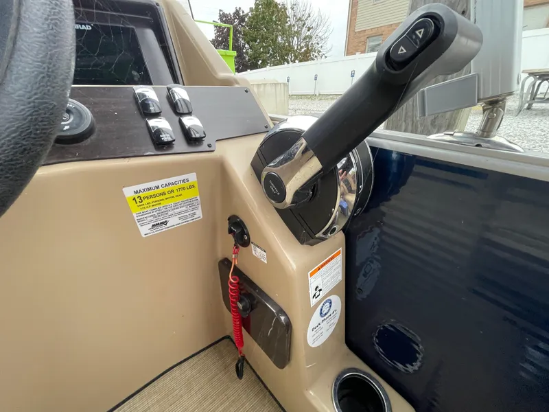 Slide: The Image of 2023 Harris Cruiser 230 boat control panel with throttle and safety features. - 24