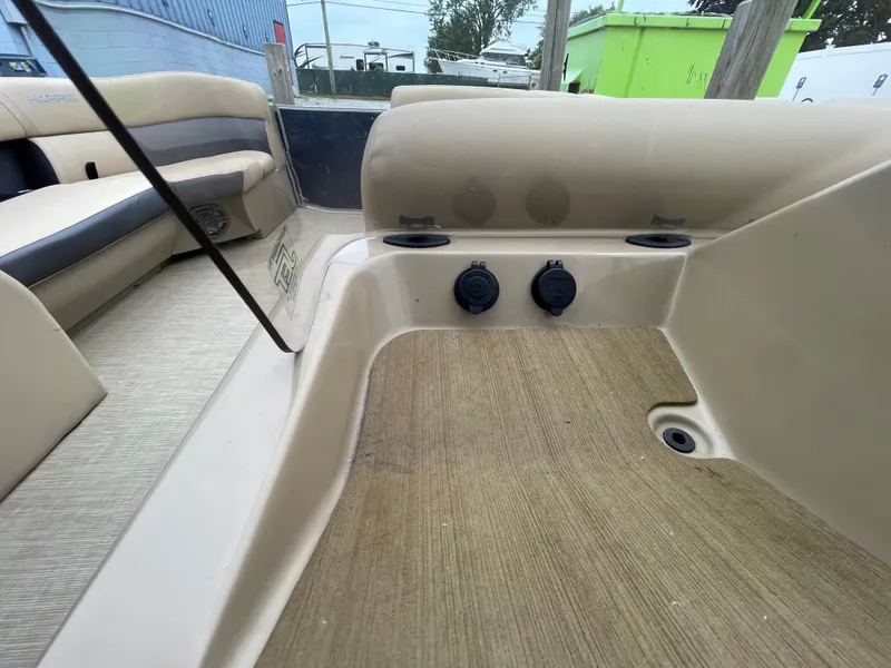 Slide: The Image of 2023 Harris Cruiser 230 boat interior with beige seating and deck. - 27