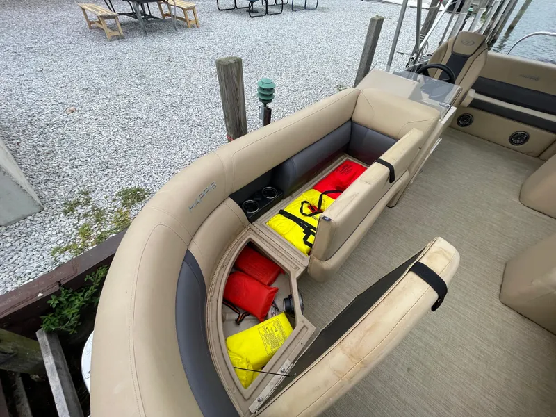 Slide: The Image of 2023 Harris Cruiser 230 boat interior with open storage compartment, revealing life jackets. - 35