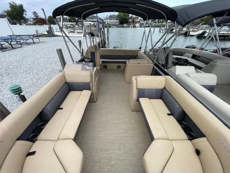 Slide: The Image of 2023 Harris Cruiser 230 pontoon boat with spacious seating and elegant design at a marina. - 36