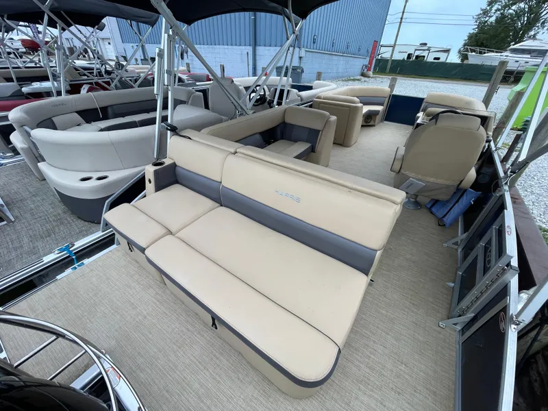 Slide: The Image of 2023 Harris Cruiser 230 pontoon boat with beige seating and spacious deck layout. - 9