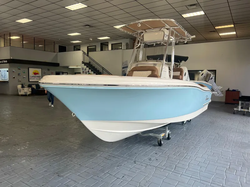 Slide: The Image of 2025 Pioneer 202 Islander boat in showroom, light blue hull, modern design. - 0