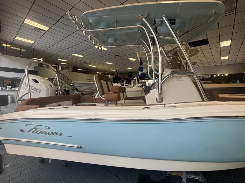 Slide: The Image of 2025 Pioneer 202 Islander boat with blue hull and T-top in showroom. - 11