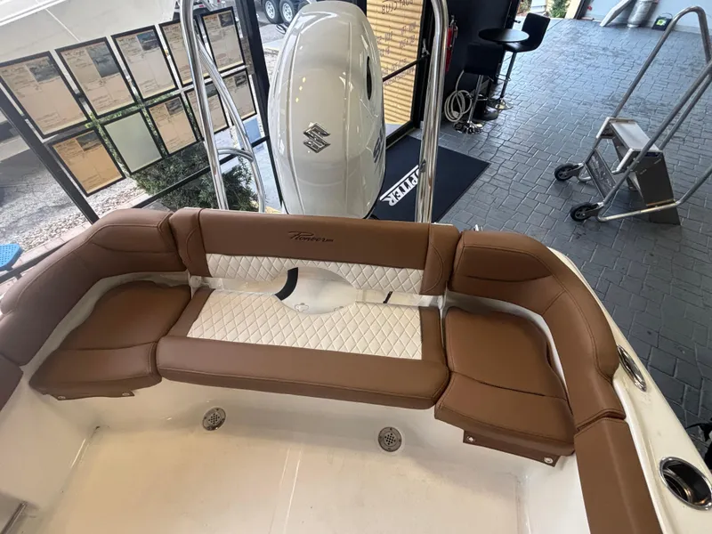 Slide: The Image of 2025 Pioneer 202 Islander boat interior with brown seating and white accents. - 2