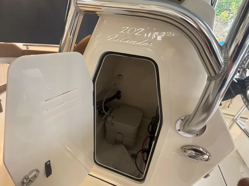 Slide: The Image of 2025 Pioneer 202 Islander boat interior storage compartment with open door. - 7