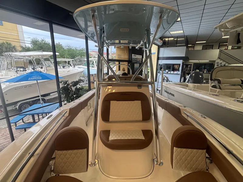 Slide: The Image of 2025 Pioneer 202 Islander boat interior with brown and white seating, showroom display. - 9