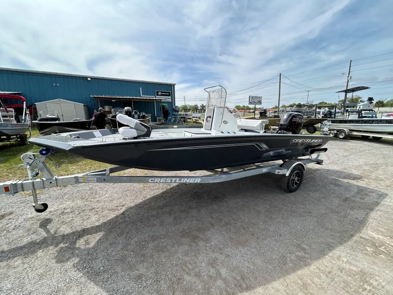 Slide: The Image of 2025 Crestliner 1800 Bay boat on trailer, parked outdoors under cloudy sky. - 1