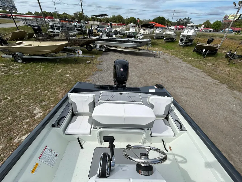 Slide: The Image of 2025 Crestliner 1800 Bay boat interior with steering wheel and seating, displayed outdoors. - 16