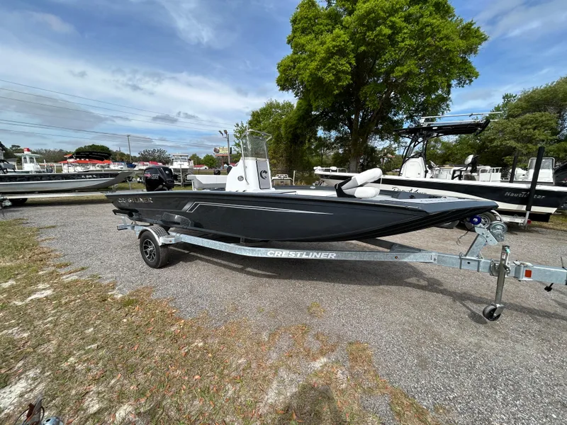 Slide: The Image of 2025 Crestliner 1800 Bay boat on trailer, parked outdoors under a cloudy sky. - 5