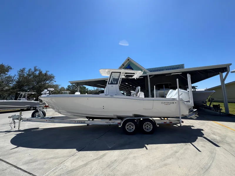 Slide: The Image of 2025 Caymas 291 boat on trailer under clear blue sky. - 1